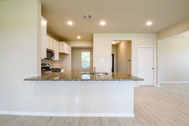 2103 Islawild Way, Texas City, TX 77568 - kitchen with appliances with stainless steel finishes, a sink, dark stone counters, white cabinetry, and recessed lighting