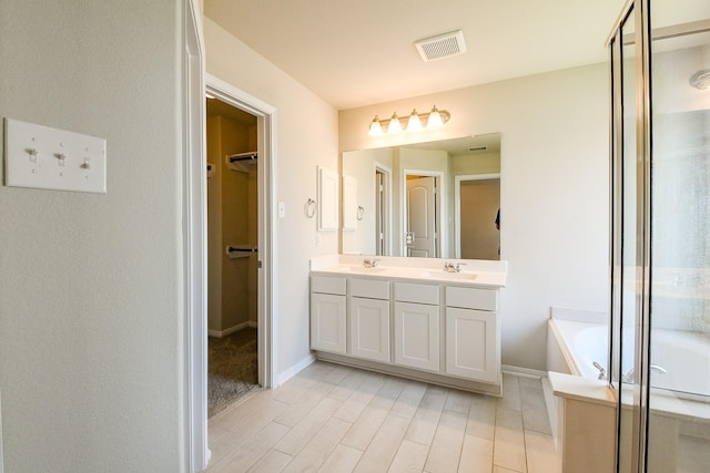 2103 Islawild Way, Texas City, TX 77568 - full bath featuring double vanity, a bath, a spacious closet, a shower stall, and baseboards