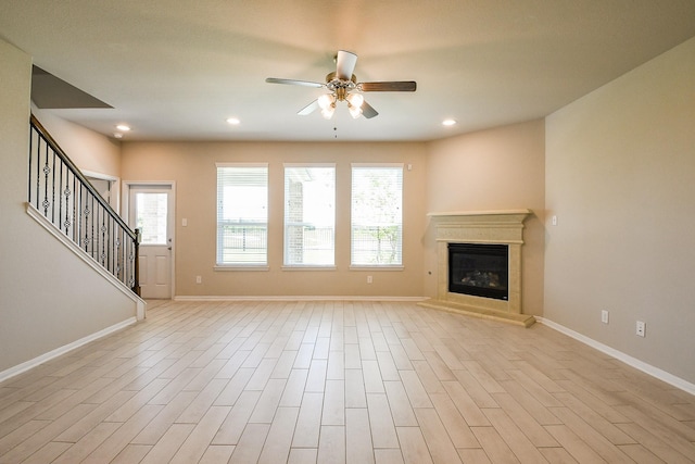 2103 Islawild Way, Texas City, TX 77568 - unfurnished living room featuring ceiling fan, plenty of natural light, a glass covered fireplace, baseboards, and recessed lighting