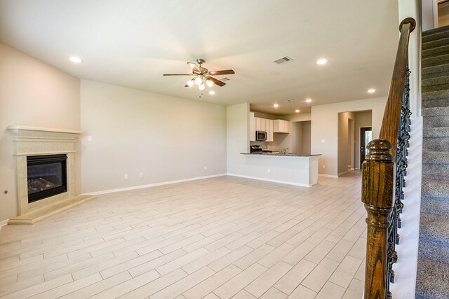 2103 Islawild Way, Texas City, TX 77568 - unfurnished living room with a ceiling fan, recessed lighting, stairs, a glass covered fireplace, and baseboards