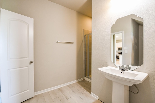 2103 Islawild Way, Texas City, TX 77568 - bathroom with a stall shower, wood finished floors, baseboards, and a sink