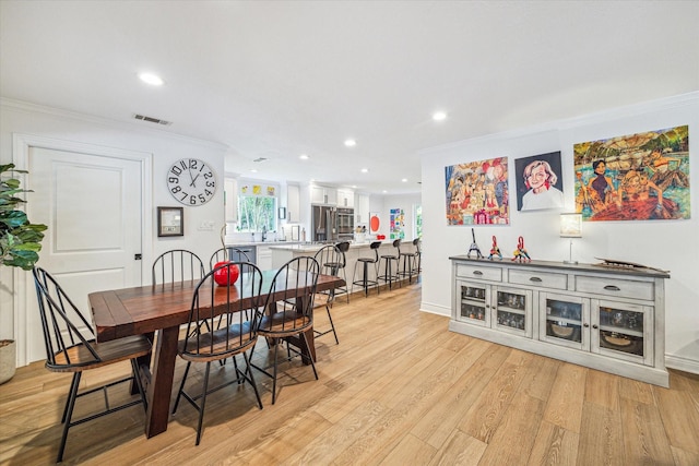 dining room featuring light wood-type flooring, visible vents, recessed lighting, and crown molding