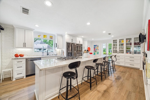 kitchen featuring white cabinets, light wood-style flooring, and appliances with stainless steel finishes