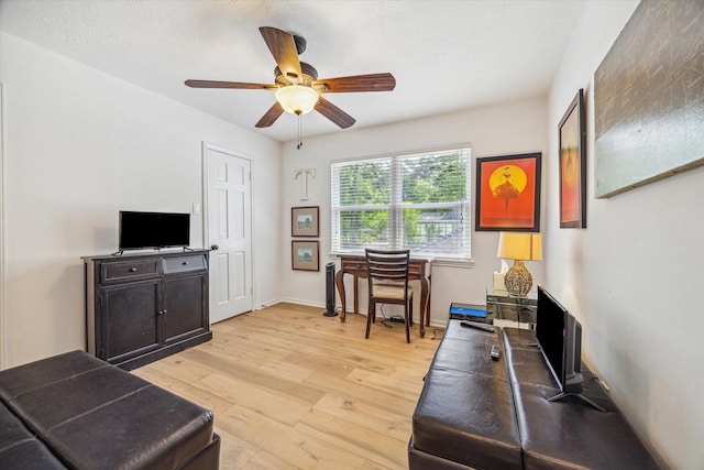 interior space with baseboards, a ceiling fan, and light wood-style flooring