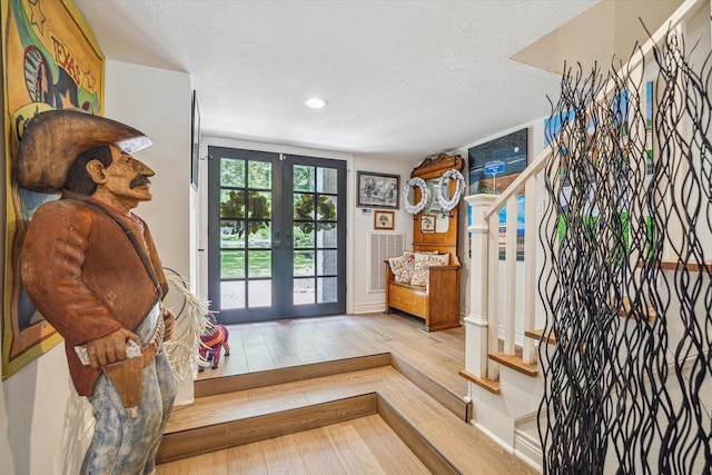 doorway featuring stairway, a textured ceiling, hardwood / wood-style floors, french doors, and recessed lighting