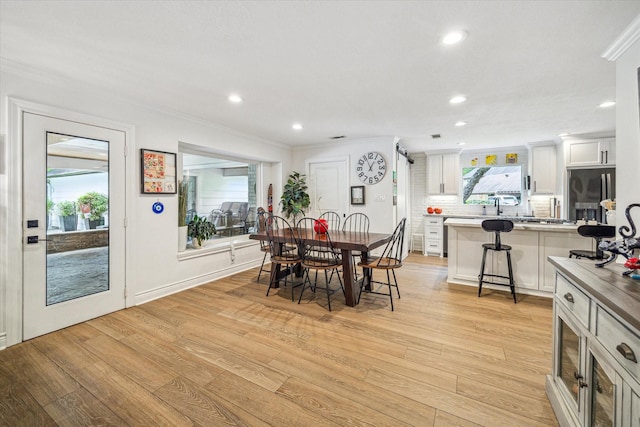 dining room featuring recessed lighting, ornamental molding, and light wood-style flooring