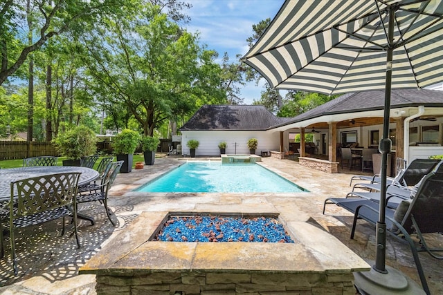 view of swimming pool featuring an outdoor fire pit, fence private yard, outdoor dining area, a patio, and ceiling fan