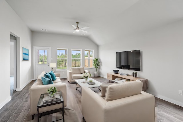 living room featuring vaulted ceiling, visible vents, wood finished floors, baseboards, and ceiling fan