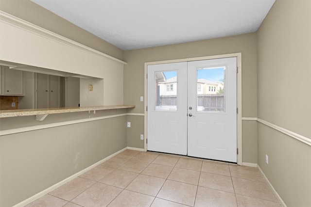 doorway to outside featuring french doors, baseboards, and light tile patterned floors
