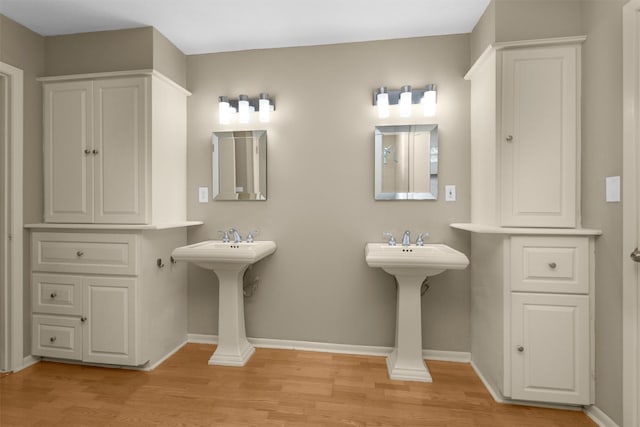 bathroom with baseboards and wood finished floors