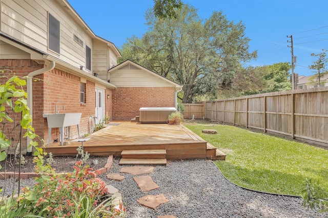 view of yard with a fenced backyard, a hot tub, and a deck