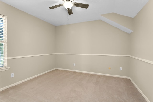 spare room featuring light colored carpet, a ceiling fan, baseboards, and a healthy amount of sunlight