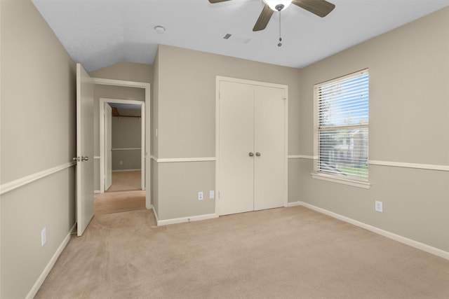 unfurnished bedroom featuring light colored carpet, baseboards, ceiling fan, and a closet