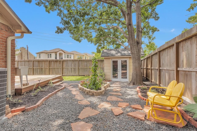 view of patio featuring a fenced backyard, an outbuilding, and french doors