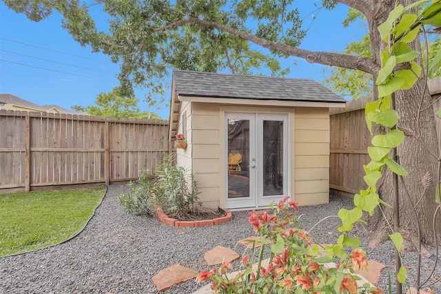 view of outbuilding with french doors, an outbuilding, and a fenced backyard