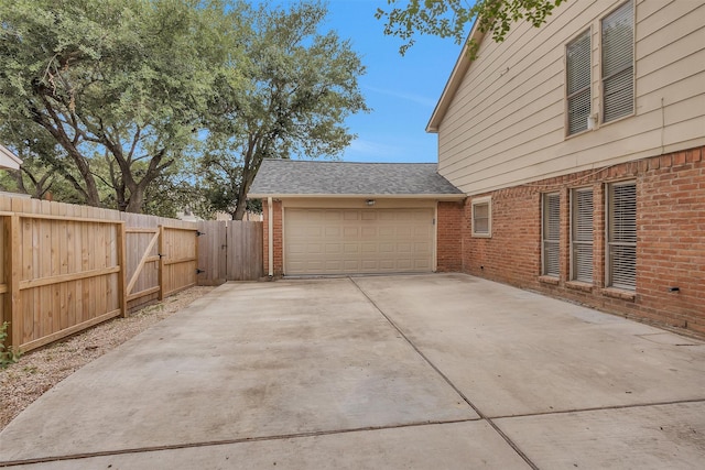 garage featuring fence and driveway