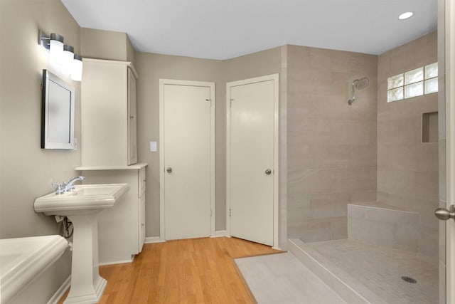 full bath with a tile shower and wood finished floors