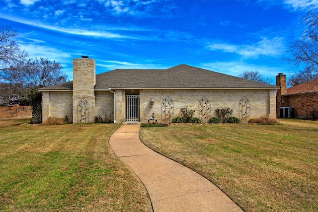 view of front of home with a chimney, an attached garage, roof with shingles, and a front yard