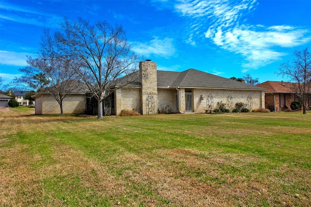 view of front of home with a front lawn, a chimney, and a garage