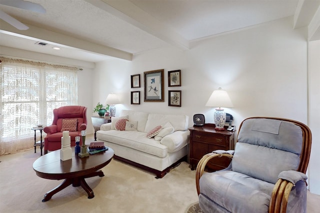 carpeted living area with beam ceiling and visible vents