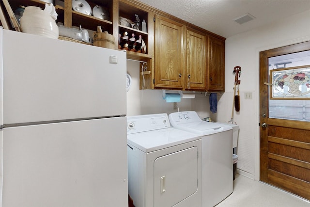 laundry room with visible vents, independent washer and dryer, and cabinet space