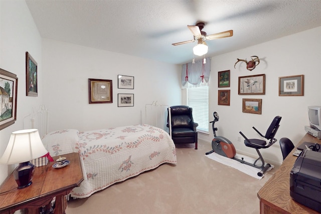 carpeted bedroom featuring ceiling fan, baseboards, and a textured ceiling