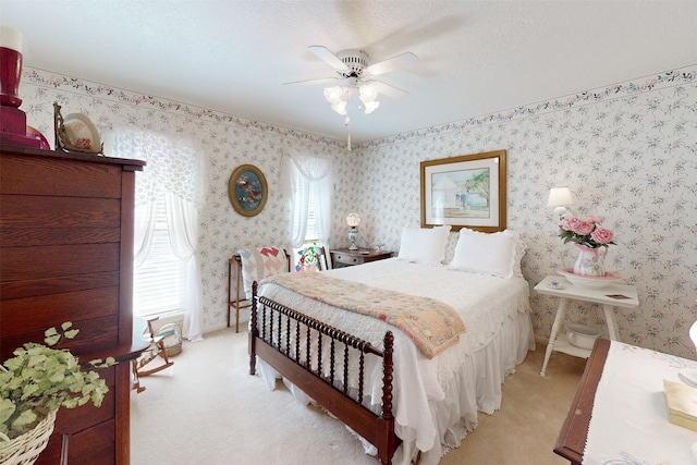 bedroom featuring wallpapered walls, ceiling fan, and light carpet