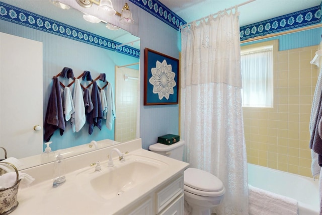 bathroom with shower / bath combo with shower curtain, vanity, and toilet