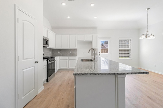 kitchen featuring white cabinetry, a sink, light wood-style floors, and appliances with stainless steel finishes