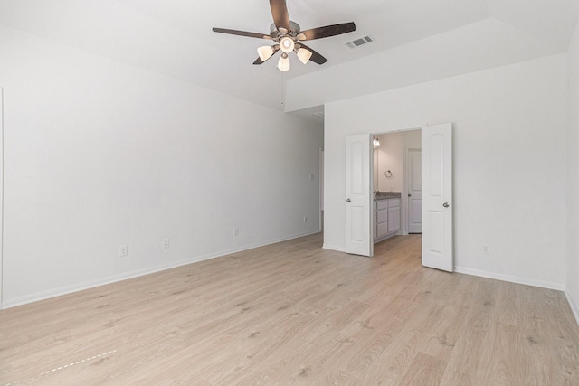 unfurnished bedroom with vaulted ceiling, baseboards, visible vents, light wood-style floors, and connected bathroom