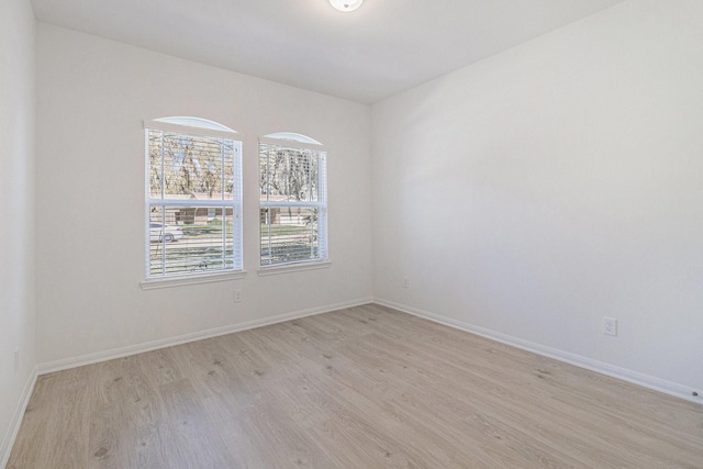 empty room featuring baseboards and light wood-style floors