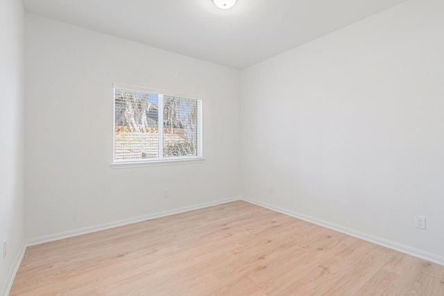 unfurnished room featuring baseboards and light wood-style flooring