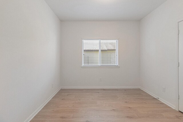 empty room with baseboards and light wood-style floors