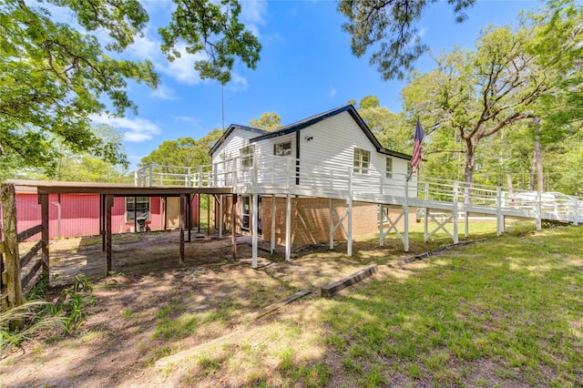 rear view of house with a wooden deck and a yard