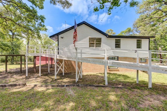 rear view of property with fence, a wooden deck, and a yard