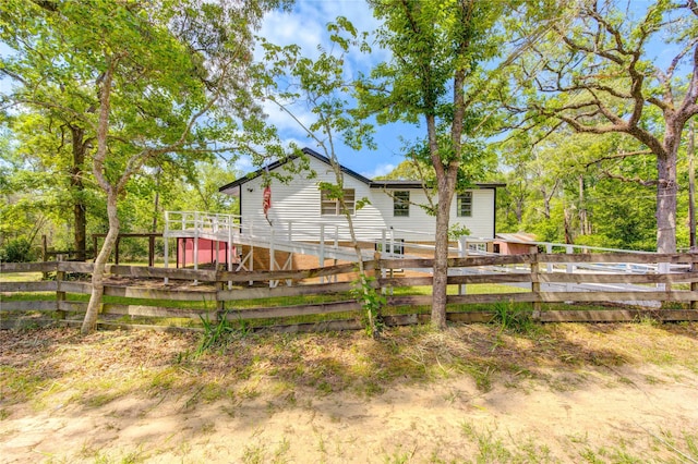back of house featuring fence and a deck