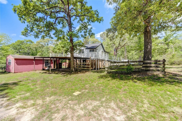 view of yard featuring fence, an outbuilding, and a deck