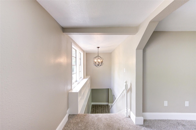 staircase featuring carpet floors, baseboards, and an inviting chandelier