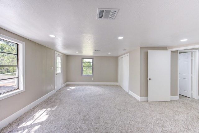 unfurnished room featuring light colored carpet, baseboards, visible vents, and recessed lighting