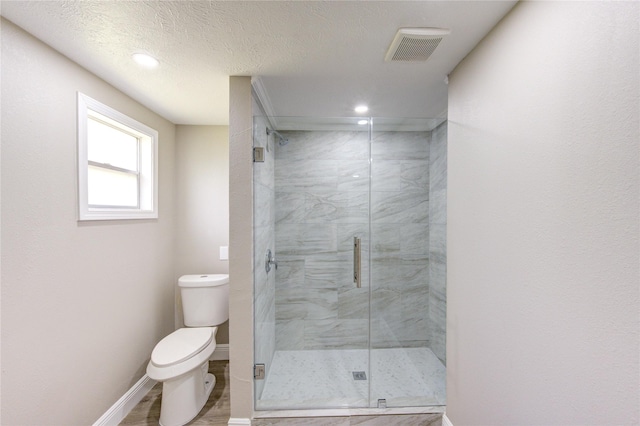 bathroom featuring baseboards, toilet, visible vents, and a stall shower