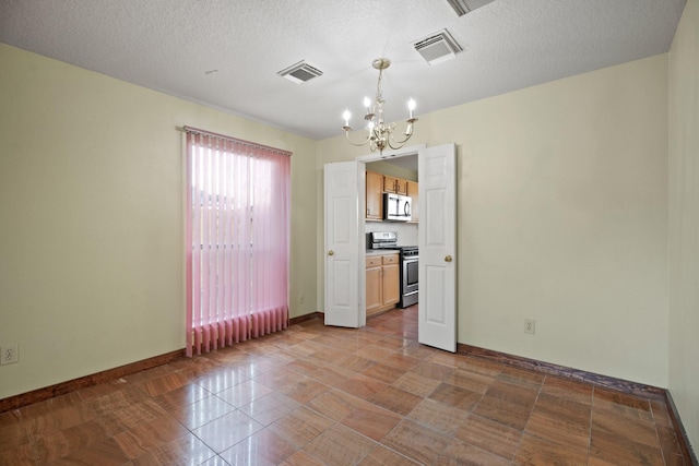 unfurnished dining area featuring baseboards, visible vents, and a notable chandelier