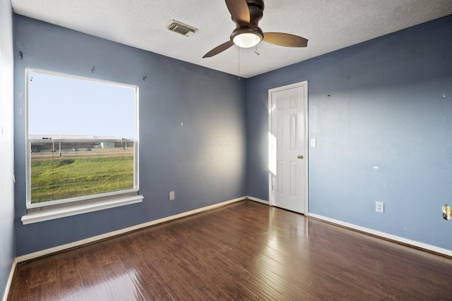 unfurnished room featuring a ceiling fan, wood finished floors, a textured ceiling, baseboards, and visible vents