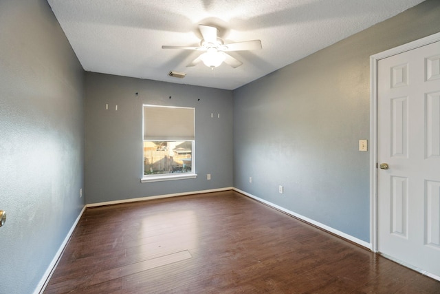 unfurnished room with a textured ceiling, baseboards, visible vents, wood finished floors, and ceiling fan
