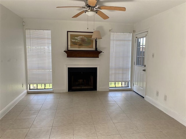 unfurnished living room featuring ceiling fan, baseboards, a fireplace, and light tile patterned floors