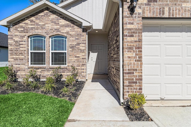 view of exterior entry featuring brick siding, board and batten siding, and a garage