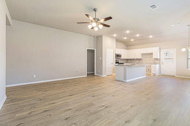 kitchen featuring open floor plan, visible vents, stainless steel microwave, and ceiling fan