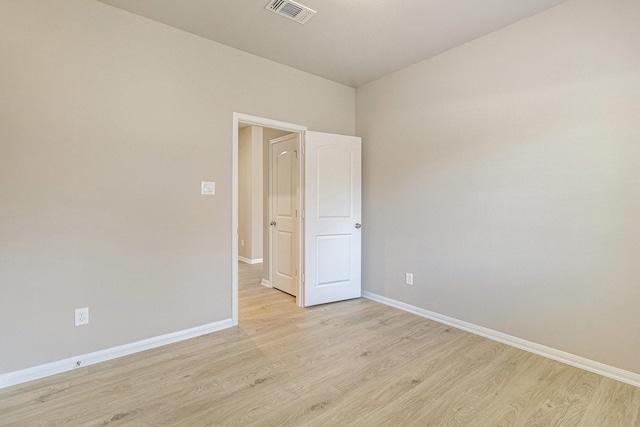unfurnished room featuring visible vents, light wood finished floors, and baseboards
