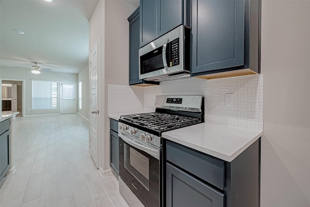 24709 Stablewood Forest Ct, Huffman, TX 77336 - kitchen featuring stainless steel appliances, tasteful backsplash, ceiling fan, baseboards, and gray cabinetry