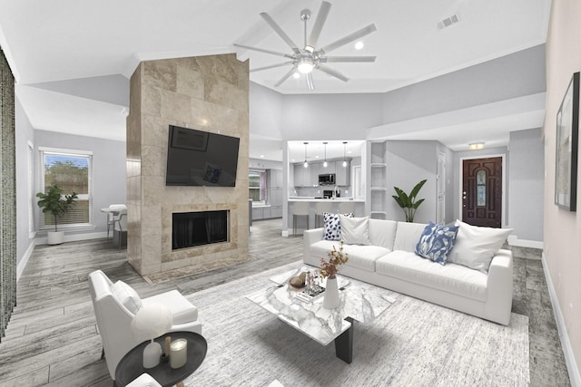 living room featuring light wood-style flooring, visible vents, a ceiling fan, and baseboards