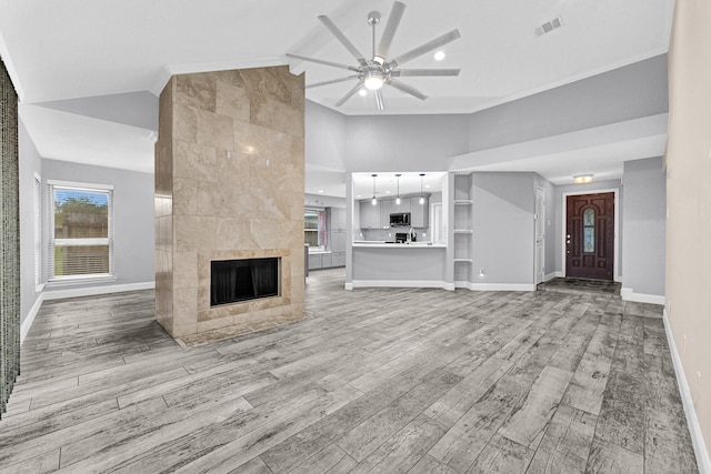 unfurnished living room featuring light wood finished floors, visible vents, a ceiling fan, and baseboards